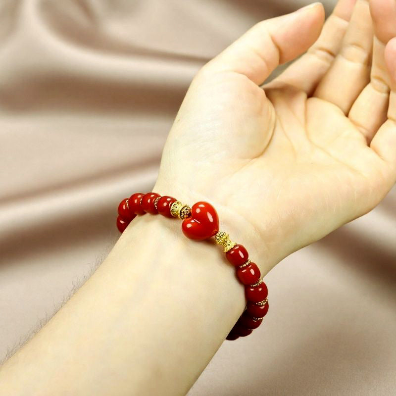 Red agate barrel bead heart bracelet with gold spacers – orange-red luster and gold bow clasp, festive and romantic.