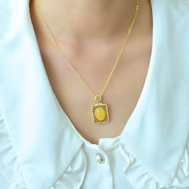 Natural amber with golden cloud pattern pendant necklace – rich, vibrant yellow amber in a courtly style, symbolizing wealth and opulence.