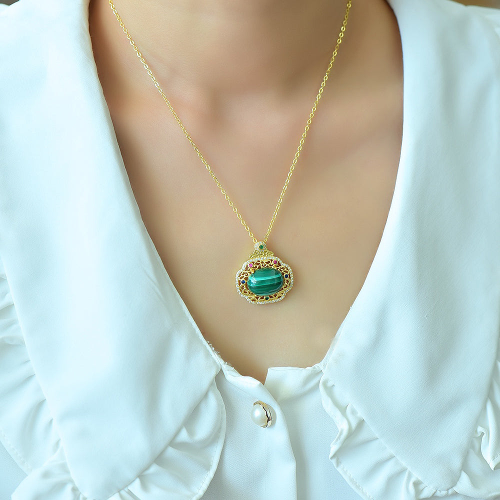 An 18K gold necklace featuring a natural malachite inlay, accented with colored gemstones and framed by an openwork border of auspicious cloud motifs.