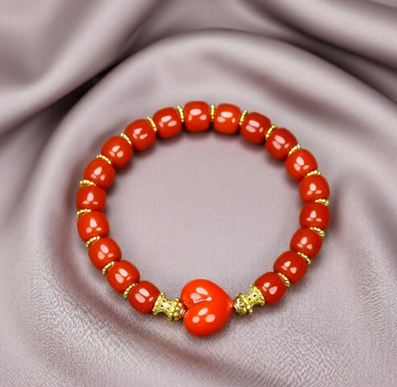 Red agate barrel bead heart bracelet with gold spacers – orange-red luster and gold bow clasp, festive and romantic.