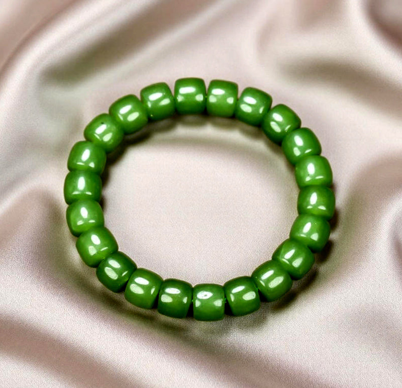 Olive green nephrite barrel bead elastic bracelet – bright and even color with a vibrant cat's-eye luster  Green symbolizes vitality, health, and good fortune