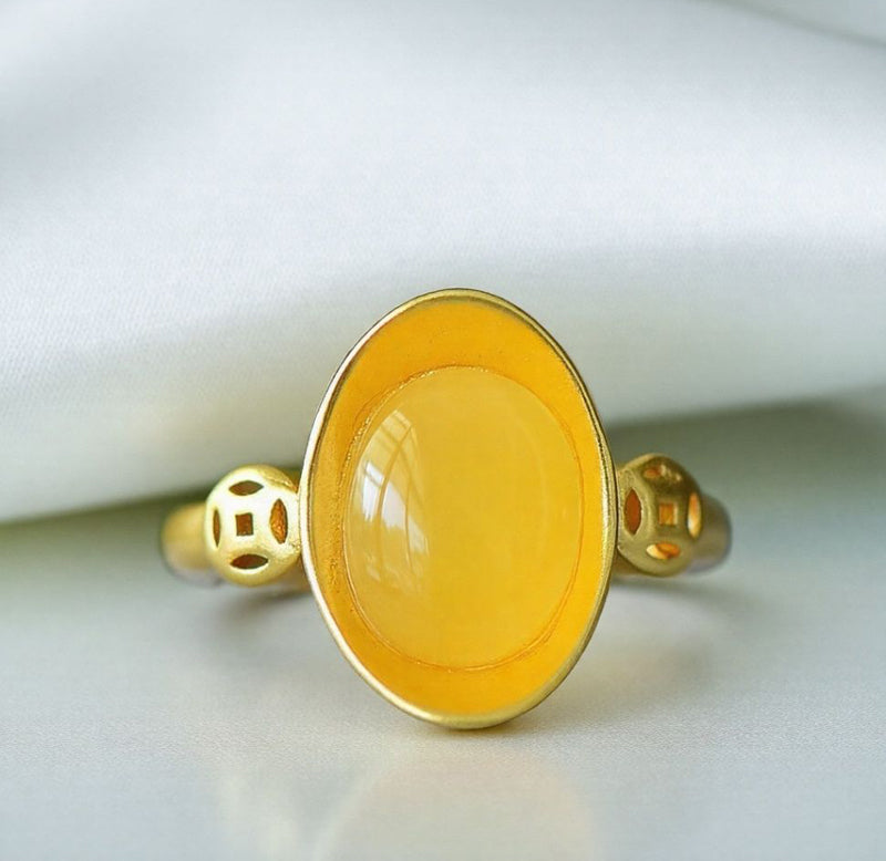 Oval amber ring with openwork ancient coin design, gold accents, warm and lustrous amber, elegant and luxurious design, comes in a beautiful gift box.
