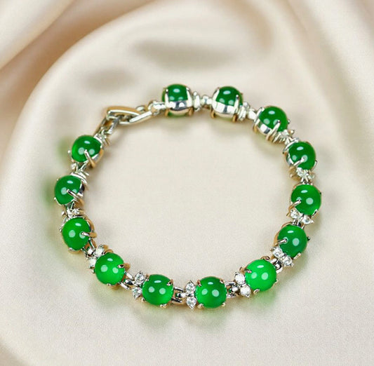 A silver four-pronged floral bracelet inlaid with emerald green jade beads – fresh, noble, exquisite, and elegant. Suitable as a gift for birthdays or holidays.