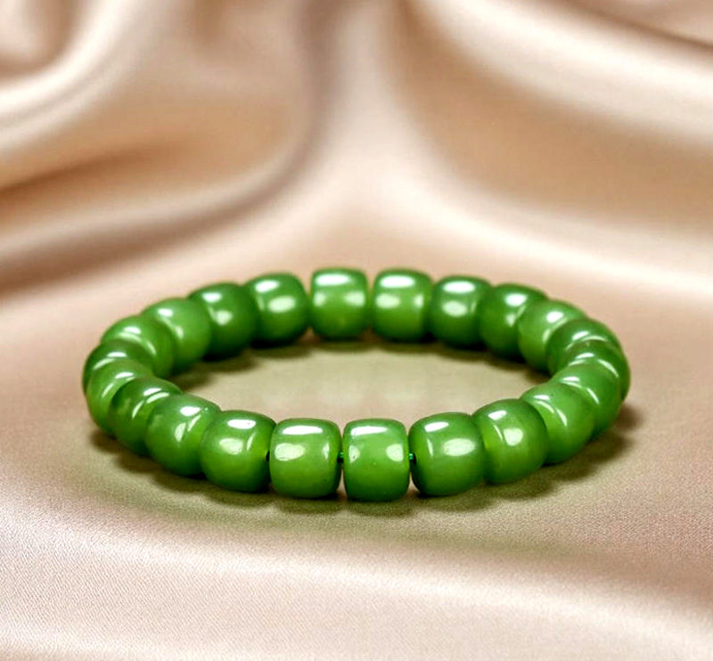 Olive green nephrite barrel bead elastic bracelet – bright and even color with a vibrant cat's-eye luster  Green symbolizes vitality, health, and good fortune