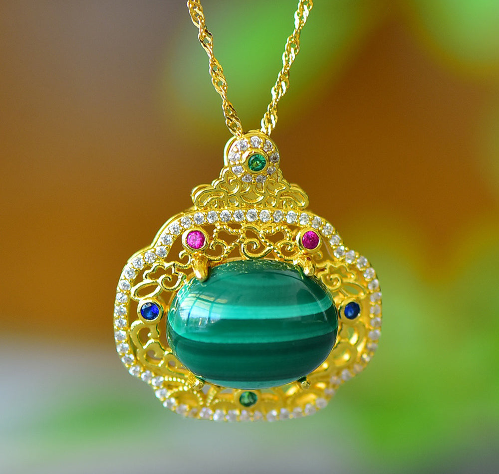An 18K gold necklace featuring a natural malachite inlay, accented with colored gemstones and framed by an openwork border of auspicious cloud motifs.
