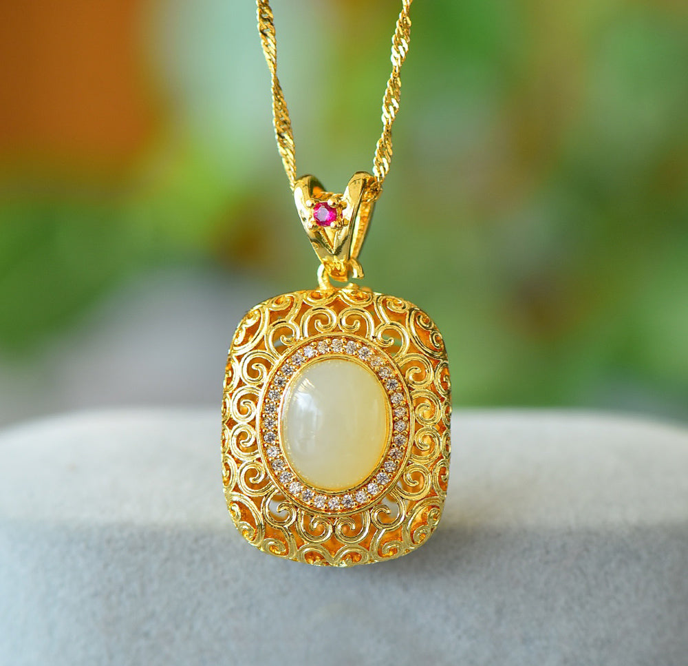 A necklace featuring a gold-tone pendant .Gold-Tone Openwork Scrollwork Box Pendant Necklace Embellished with Zircons, Luxurious & Elegant
