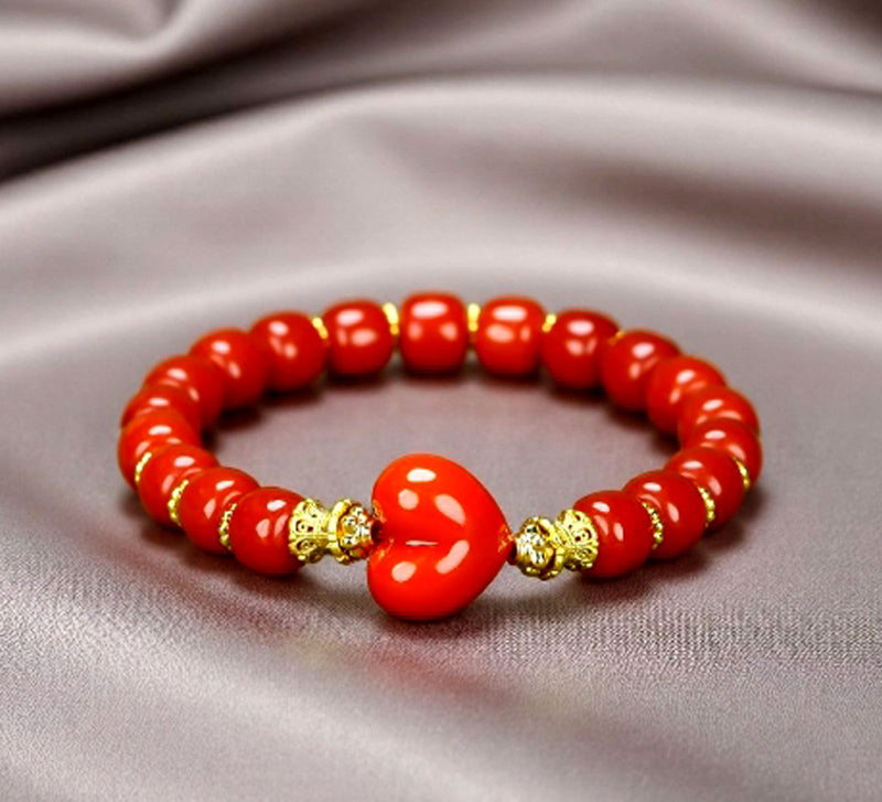 Red agate barrel bead heart bracelet with gold spacers – orange-red luster and gold bow clasp, festive and romantic.