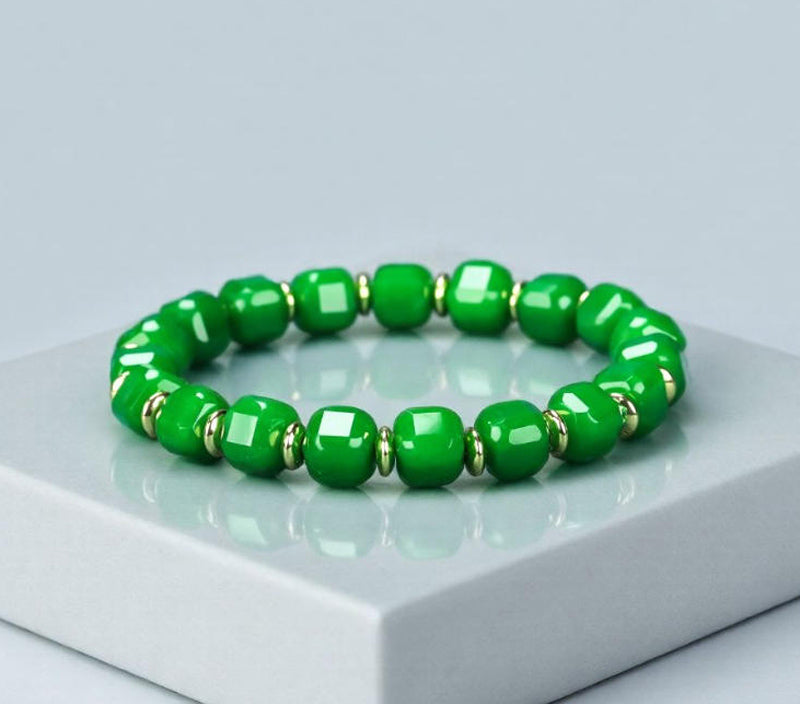 Emerald green jadeite square-cut barrel bead elastic bracelet with small gold round pieces spaced apart, fresh and elegant.