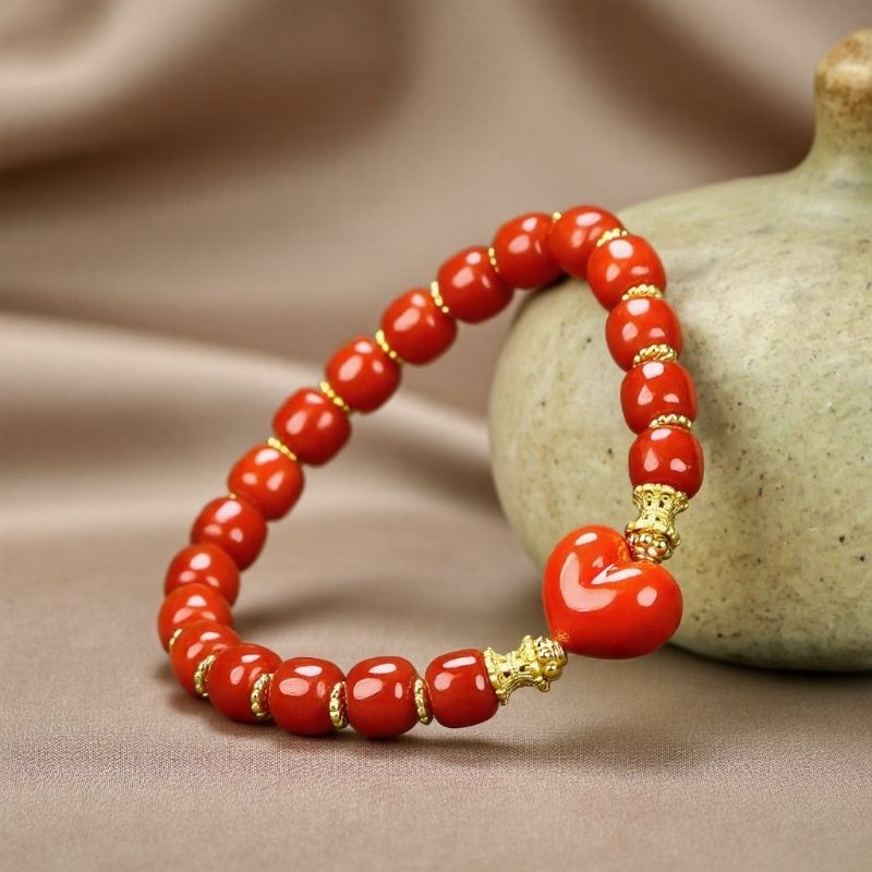 Red agate barrel bead heart bracelet with gold spacers – orange-red luster and gold bow clasp, festive and romantic.