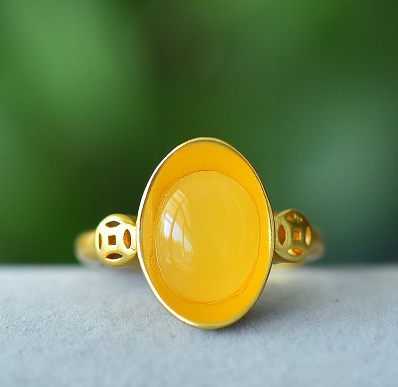 Oval amber ring with openwork ancient coin design, gold accents, warm and lustrous amber, elegant and luxurious design, comes in a beautiful gift box.