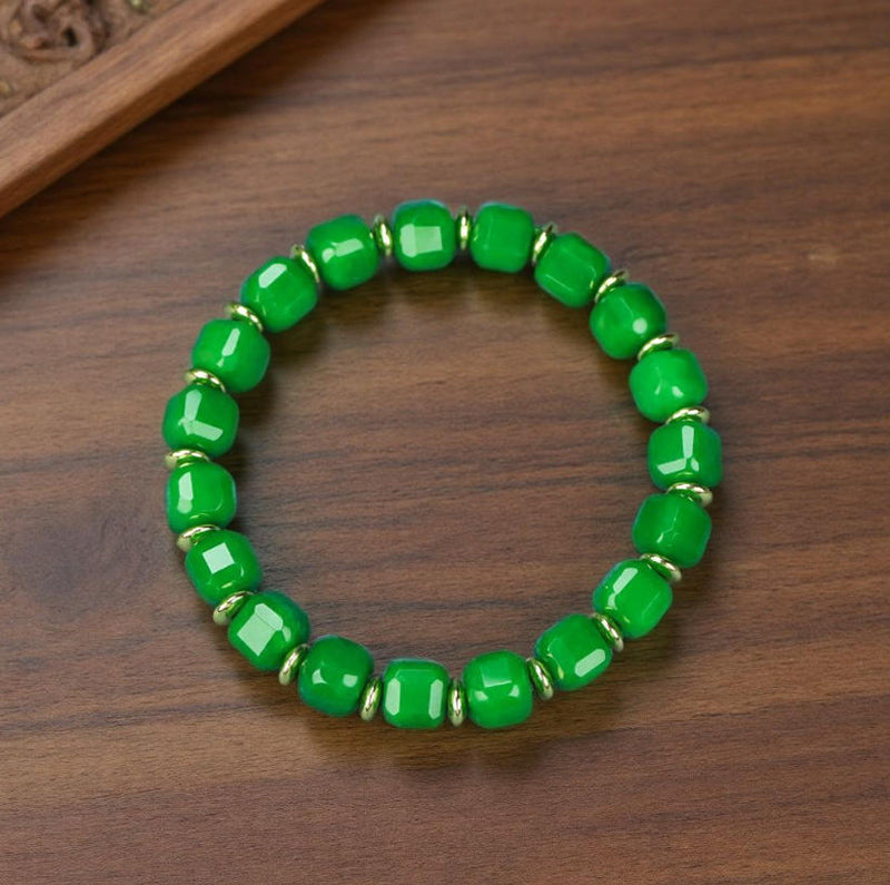 Emerald green jadeite square-cut barrel bead elastic bracelet with small gold round pieces spaced apart, fresh and elegant.
