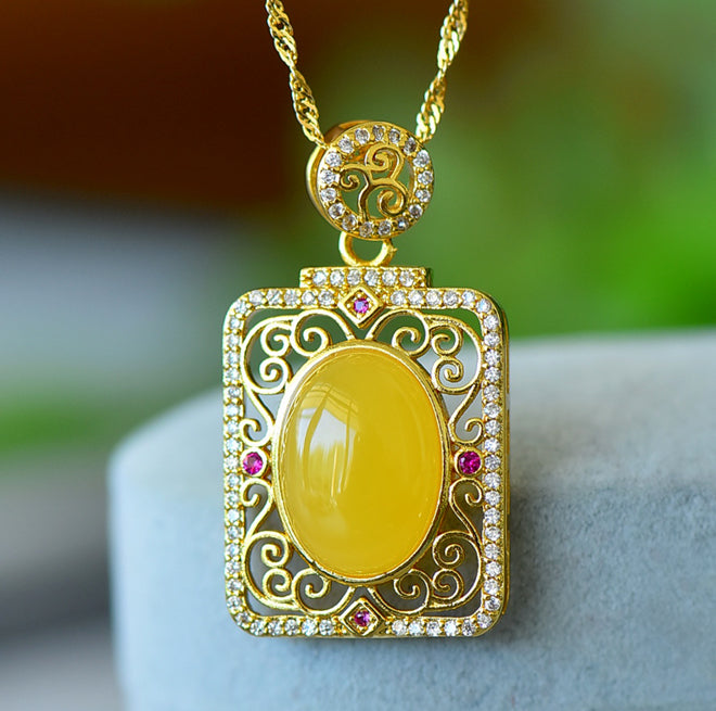 Natural amber with golden cloud pattern pendant necklace – rich, vibrant yellow amber in a courtly style, symbolizing wealth and opulence.