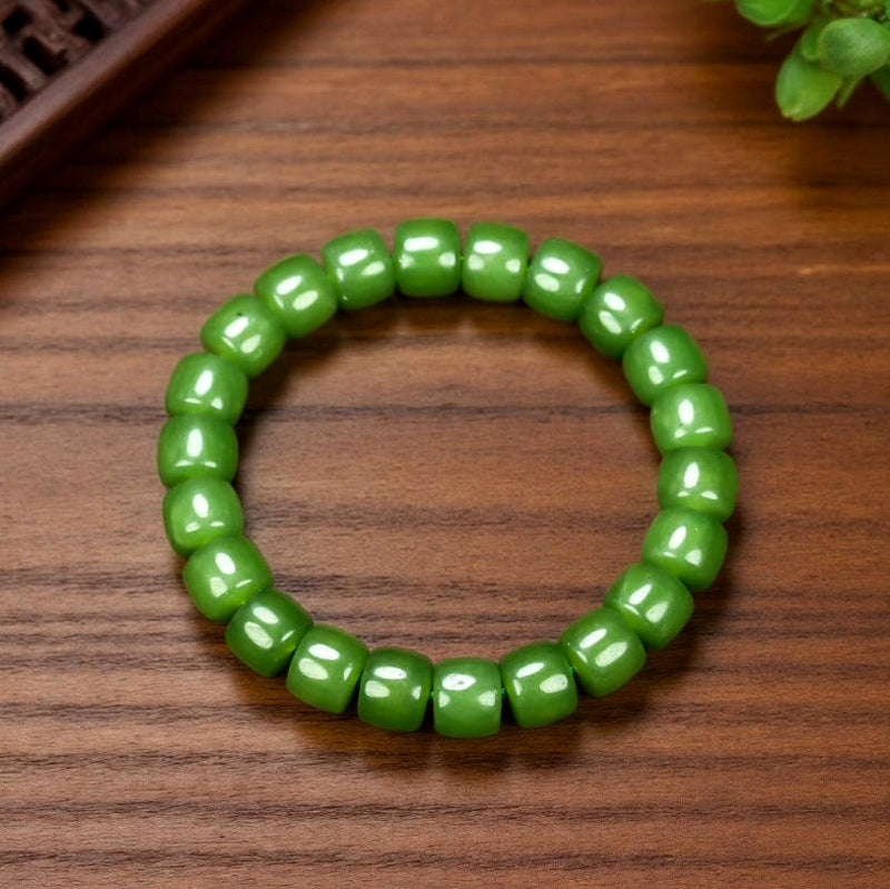 Olive green nephrite barrel bead elastic bracelet – bright and even color with a vibrant cat's-eye luster  Green symbolizes vitality, health, and good fortune