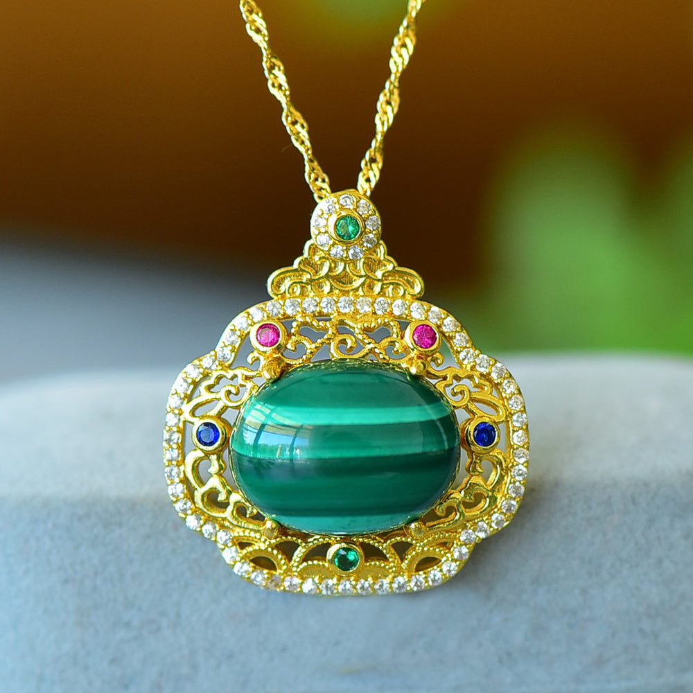 An 18K gold necklace featuring a natural malachite inlay, accented with colored gemstones and framed by an openwork border of auspicious cloud motifs.