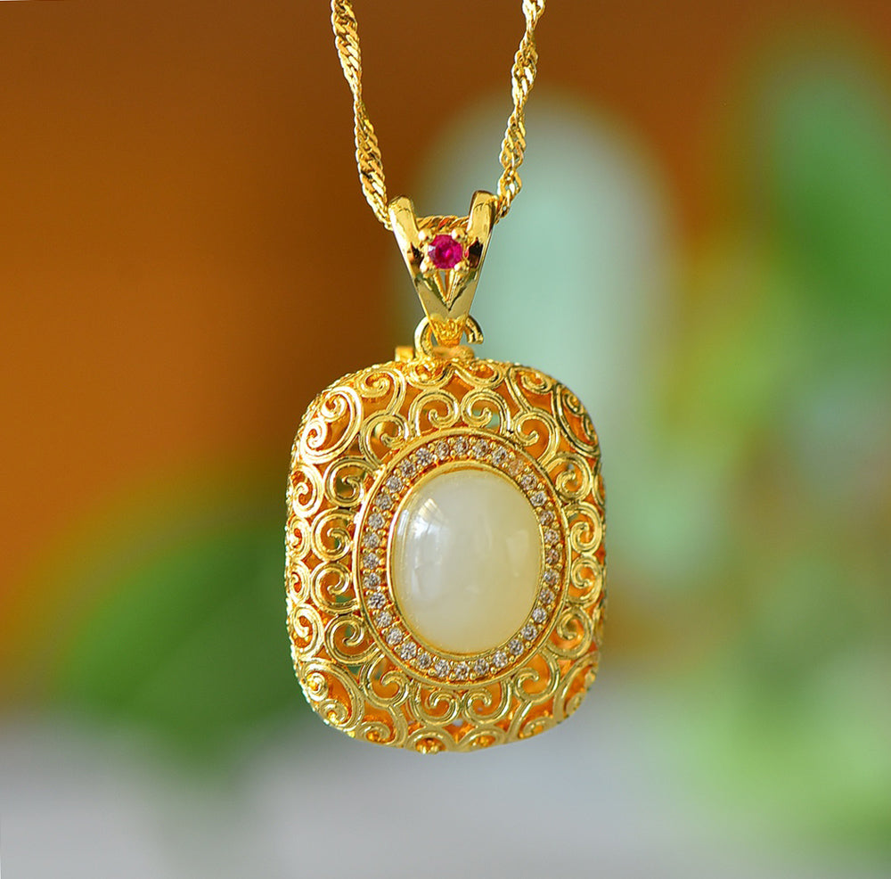 A necklace featuring a gold-tone pendant .Gold-Tone Openwork Scrollwork Box Pendant Necklace Embellished with Zircons, Luxurious & Elegant