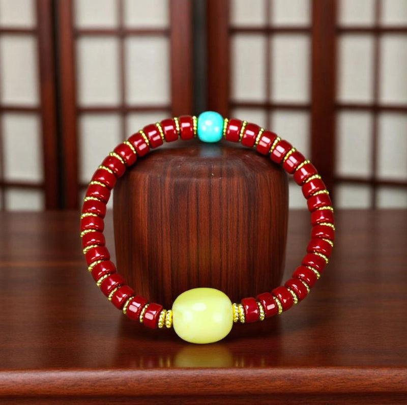 A bracelet made of Southern Red Agate pill beads, featuring a yellow amber main bead and turquoise accents, showcasing three colors.