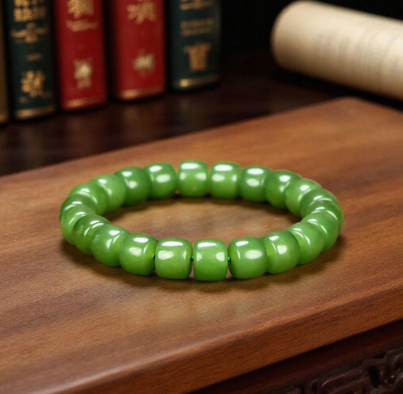 Olive green nephrite barrel bead elastic bracelet – bright and even color with a vibrant cat's-eye luster  Green symbolizes vitality, health, and good fortune