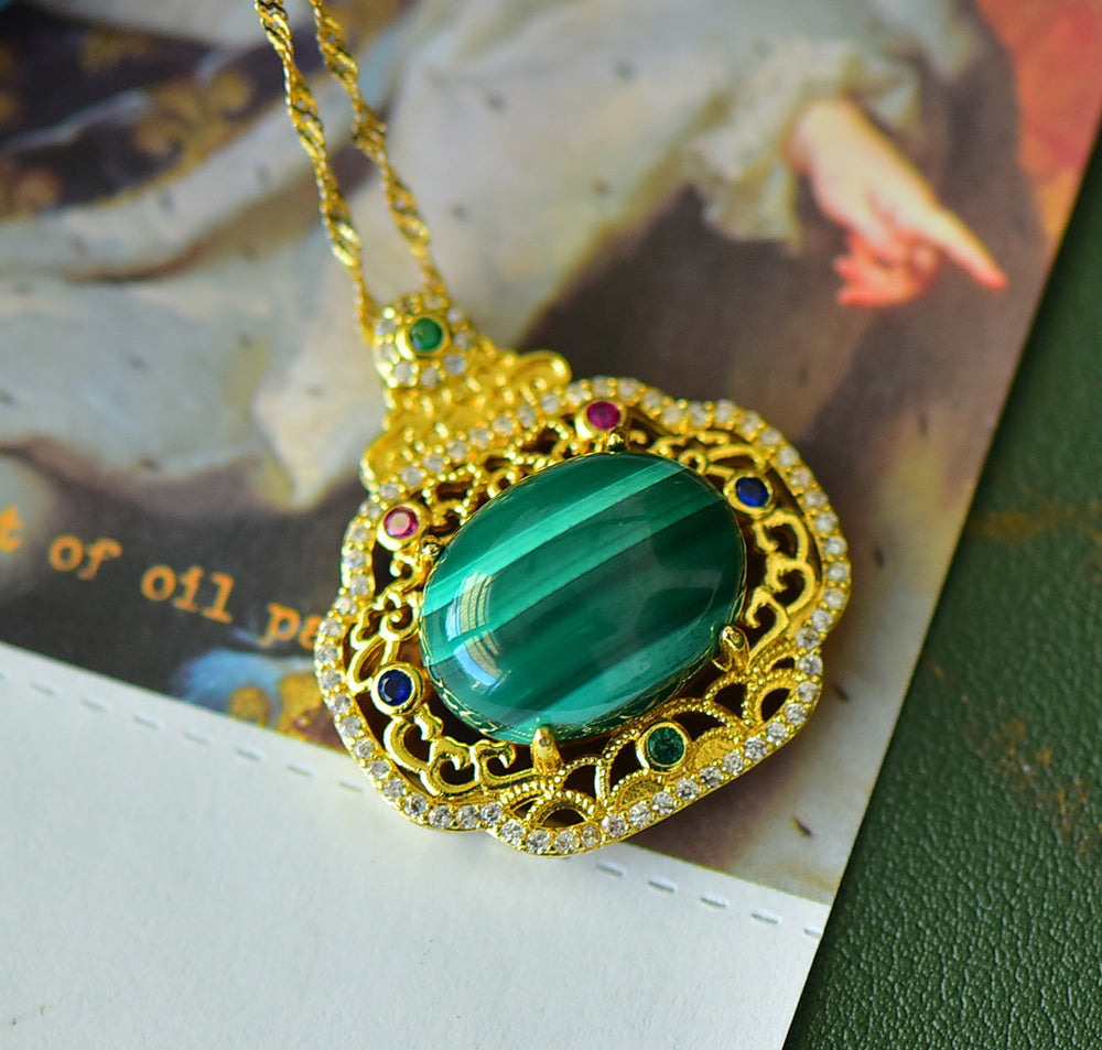 An 18K gold necklace featuring a natural malachite inlay, accented with colored gemstones and framed by an openwork border of auspicious cloud motifs.
