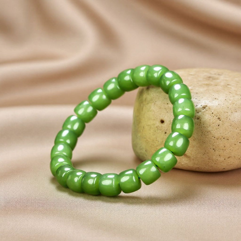 Olive green nephrite barrel bead elastic bracelet – bright and even color with a vibrant cat's-eye luster  Green symbolizes vitality, health, and good fortune