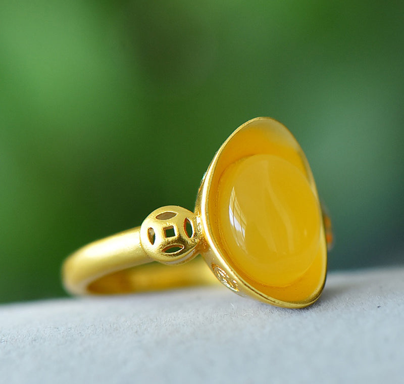 Oval amber ring with openwork ancient coin design, gold accents, warm and lustrous amber, elegant and luxurious design, comes in a beautiful gift box.