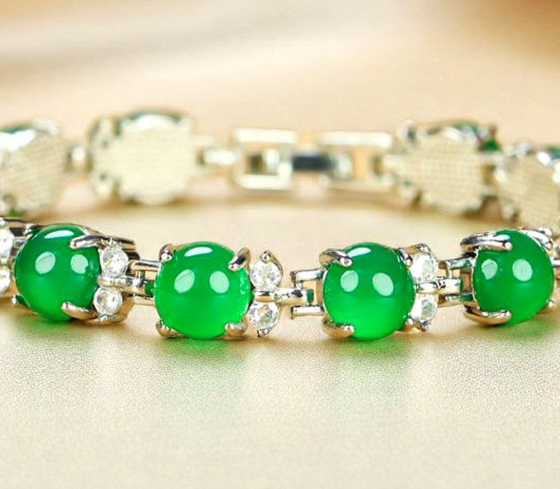 A silver four-pronged floral bracelet inlaid with emerald green jade beads – fresh, noble, exquisite, and elegant. Suitable as a gift for birthdays or holidays.