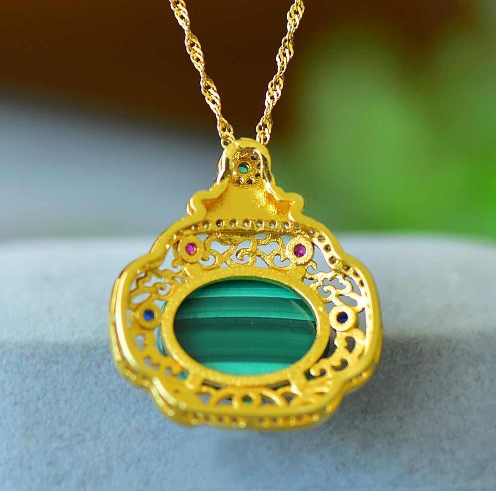 An 18K gold necklace featuring a natural malachite inlay, accented with colored gemstones and framed by an openwork border of auspicious cloud motifs.