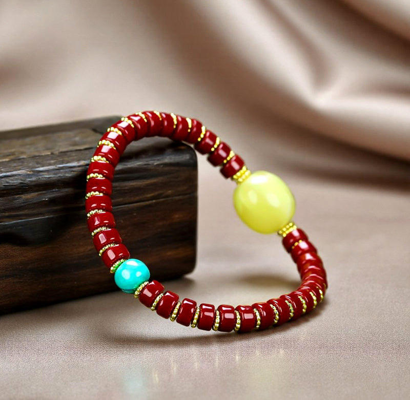 A bracelet made of Southern Red Agate pill beads, featuring a yellow amber main bead and turquoise accents, showcasing three colors.