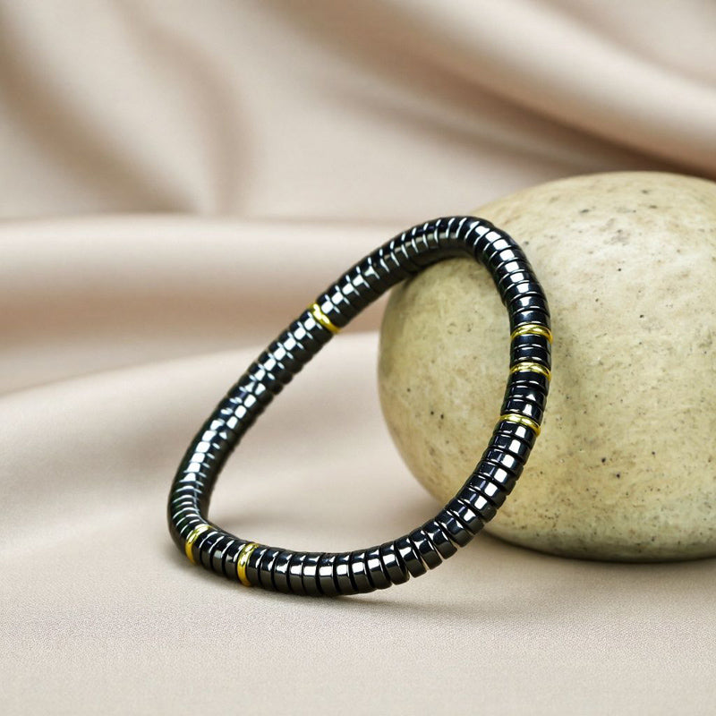 Black Terahertz Bead and Gold Spacer Elastic Bracelet – A stylish, minimalist, unisex magnetic therapy accessory featuring a striking gold-and-black contrast.