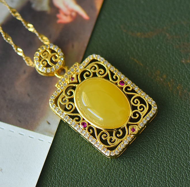Natural amber with golden cloud pattern pendant necklace – rich, vibrant yellow amber in a courtly style, symbolizing wealth and opulence.