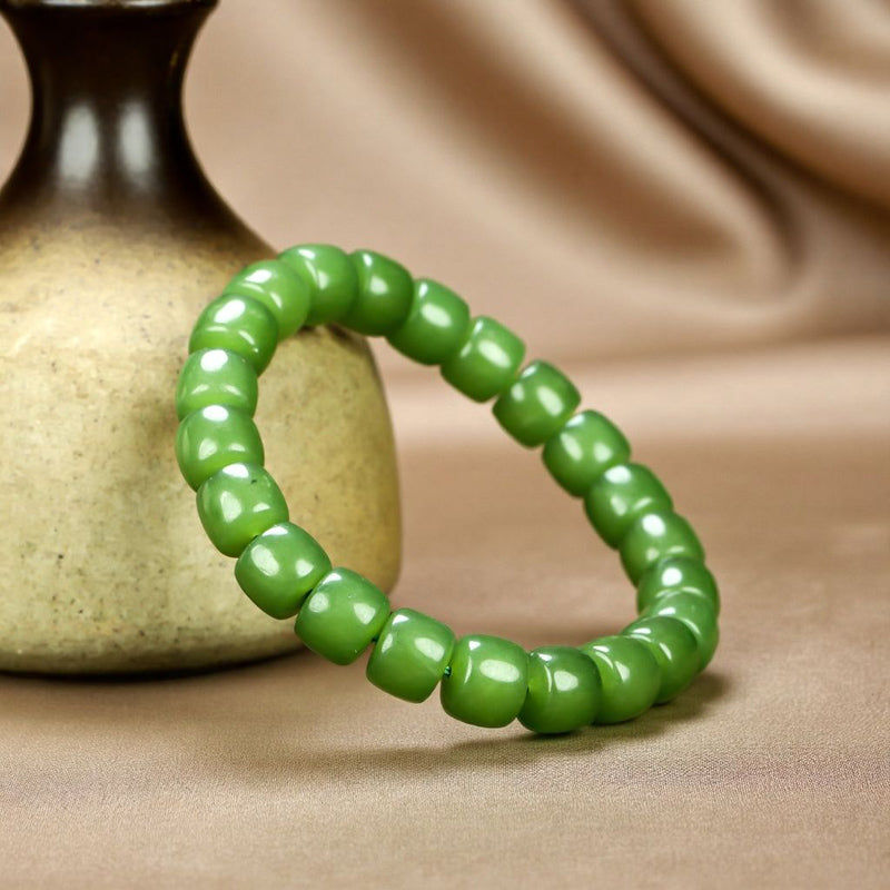 Olive green nephrite barrel bead elastic bracelet – bright and even color with a vibrant cat's-eye luster  Green symbolizes vitality, health, and good fortune