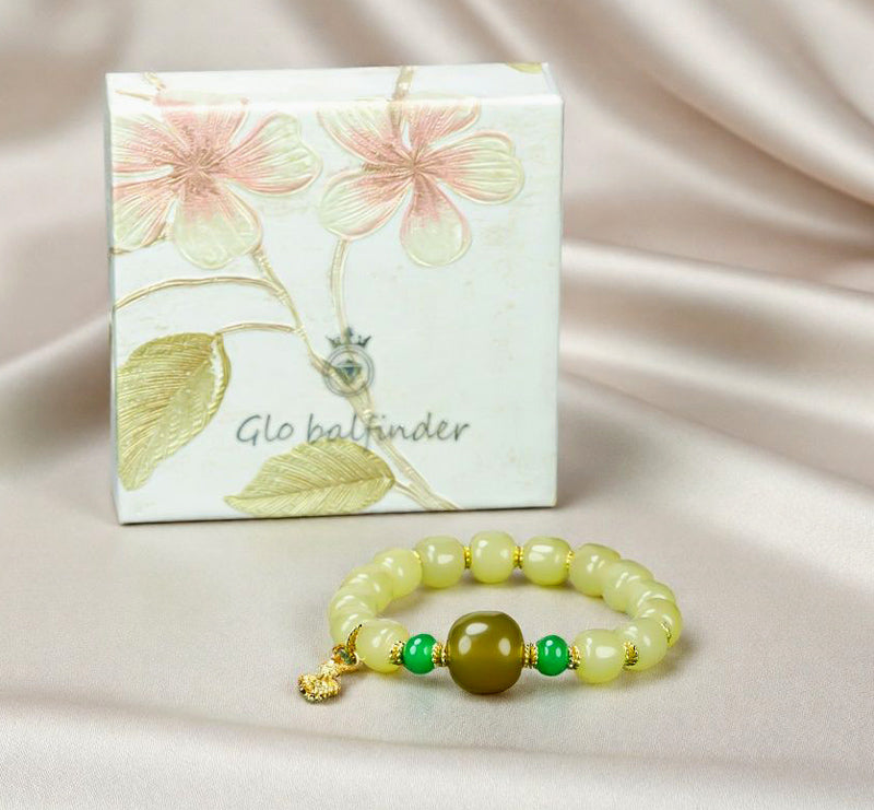Yellow-green chalcedony barrel bead bracelet featuring gold spacers, a deep olive-green main bead, emerald-green small round beads, and a gold lotus-shaped charm.