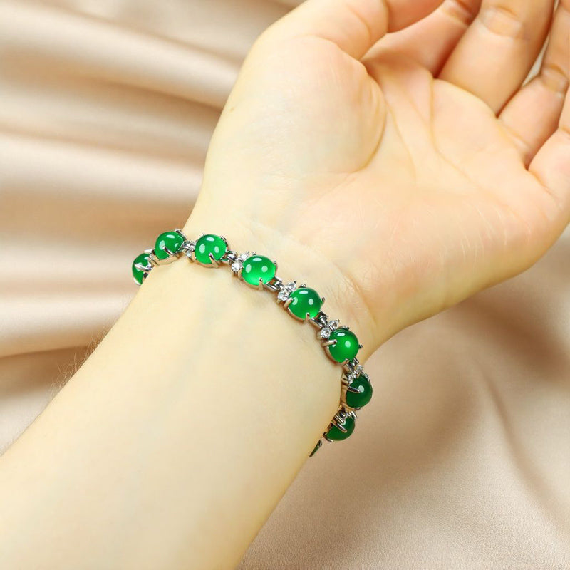 A silver four-pronged floral bracelet inlaid with emerald green jade beads – fresh, noble, exquisite, and elegant. Suitable as a gift for birthdays or holidays.