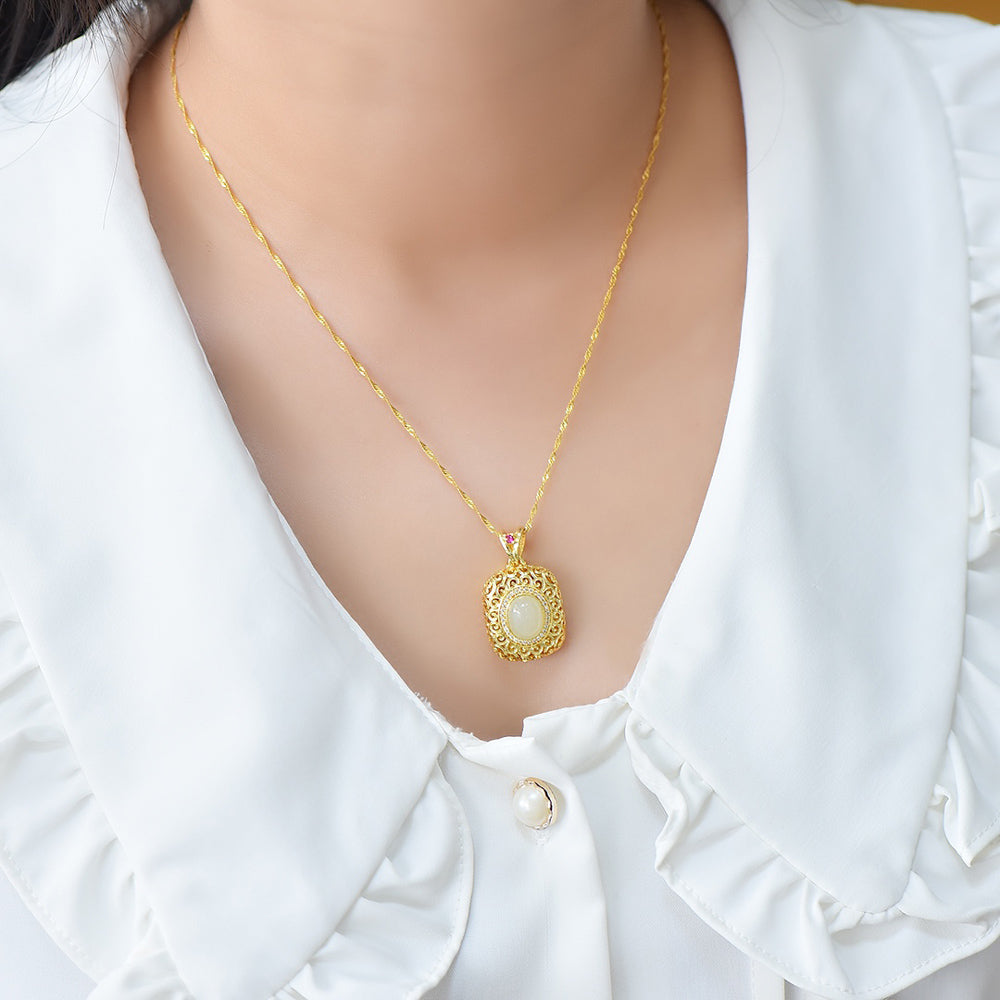 A necklace featuring a gold-tone pendant .Gold-Tone Openwork Scrollwork Box Pendant Necklace Embellished with Zircons, Luxurious & Elegant