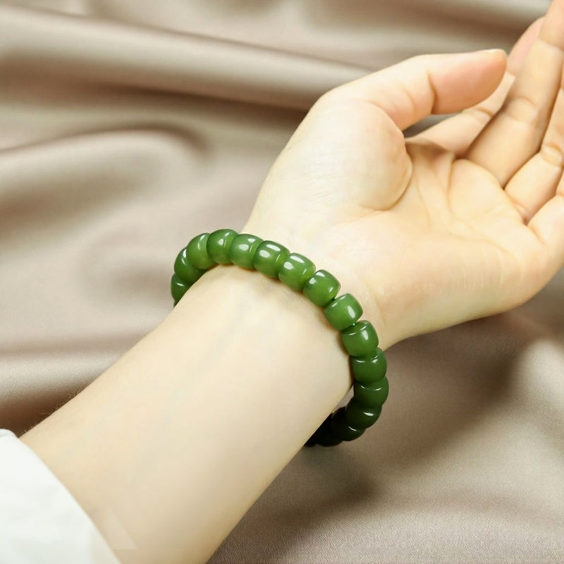 Olive green nephrite barrel bead elastic bracelet – bright and even color with a vibrant cat's-eye luster  Green symbolizes vitality, health, and good fortune