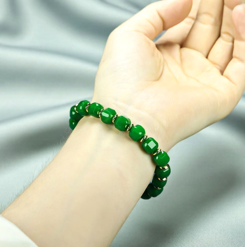 Emerald green jadeite square-cut barrel bead elastic bracelet with small gold round pieces spaced apart, fresh and elegant.