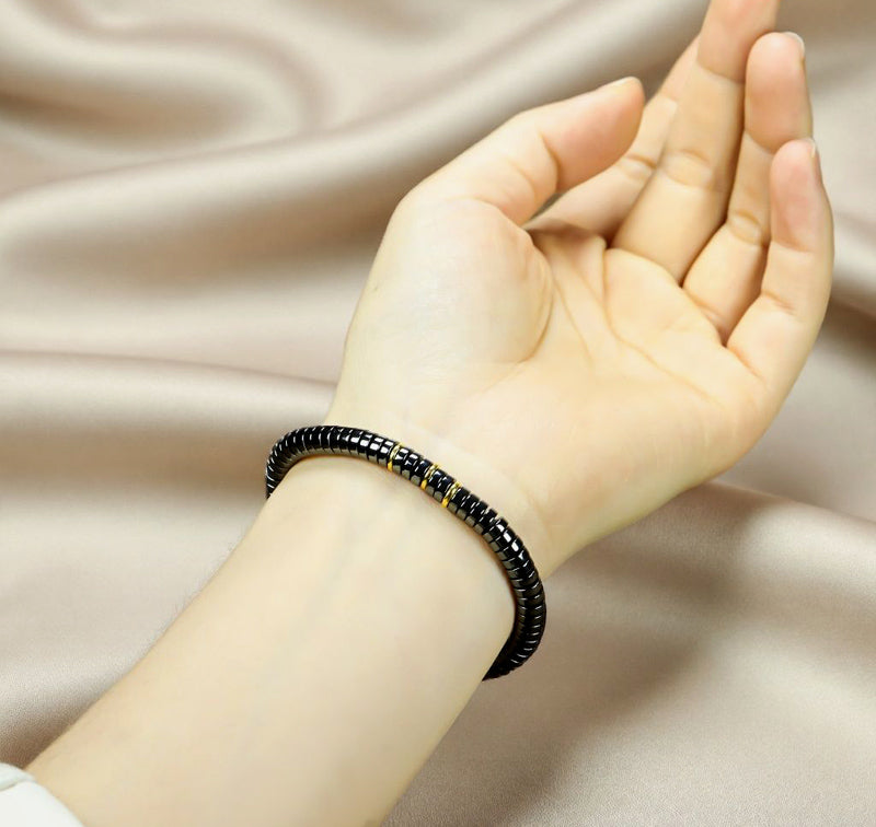 Black Terahertz Bead and Gold Spacer Elastic Bracelet – A stylish, minimalist, unisex magnetic therapy accessory featuring a striking gold-and-black contrast.